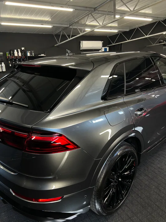 Tylny błotnik, lampa i czarna felga szarego Audi